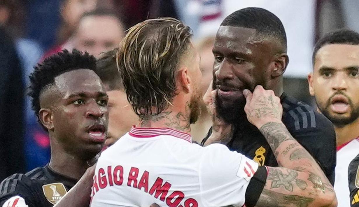 Pemain Sevilla, Sergio Ramos, mencubit pipi pemain Real Madrid, Antonio Rudiger, pada laga Liga Spanyol di Stadion Ramon Sanchez Pizjuan, Sabtu (21/10/2023). (AP Photo/Jose Breton)