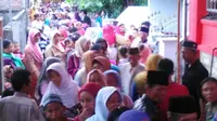 Warga mengantre pembagian zakat maal yang dibagian keluarga Ketua Timses Risma di Surabaya. (Liputan6.com/Dhimas Prasaja)