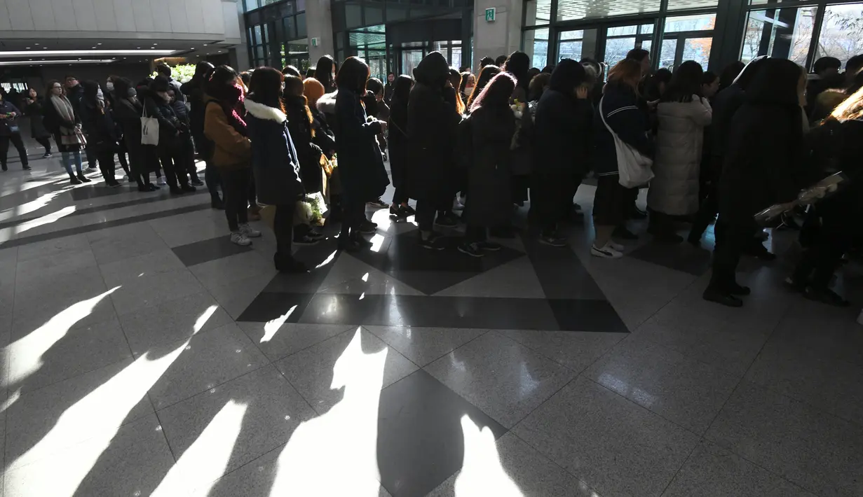 Para fans memberikan penghormatan kepada Jonghyun SHINee di rumah duka Seoul Asan Hospital, Korea Selatan, Selasa (19/12). Diungkapkan, para member SHINee yang lain akan menjadi pengiring peti mendiang Jonghyun. (JUNG Yeon-Je / AFP)