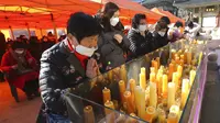 Para orangtua berdoa selama kebaktian khusus untuk mendoakan keberhasilan anak-anak mereka dalam ujian masuk perguruan tinggi di Kuil Buddha Jogyesa, Seoul, Korea Selatan, Kamis (3/12/2020). Ujian diikuti ratusan ribu siswa, termasuk puluhan siswa pasien COVID-19. (AP Photo/Ahn Young-joon)