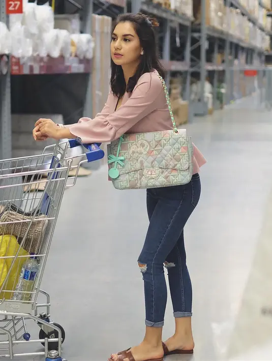 Tidak hanya saat menghadiri acara formal, namun dalam kesehariannya Ibel juga berpenampilan menarik. Seperti yang satu ini, ia memakai ripped jeans  dengan atasan berwarna baby pink. (Instagram/_irishbella_)