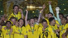Striker dan kapten Borussia Dortmund, Marco Reus (tengah) mengangkat trofi DFB Pokal di tengah-tengah rekan setim usai kemenangan 4-1 atas RB Leipzig dalam partai Final DFB Pokal 2020/2021 di Olympiastadion, Berlin, Kamis (13/5/2021). (AFP/John MacDougall/Pool)