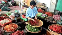 Seorang pedagang bumbu dapur merajang cabai, di Pasar Bulu Semarang, Jateng.  Harga cabai saat ini telah mencapai Rp28 ribu per kilogram atau naik lebih dari 100 persen. (Antara)