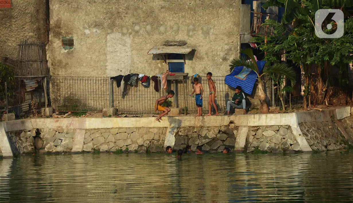 Sejumlah anak mandi di setu Rawabadung, Jakarta, Sabtu (19/10/2019). Cuaca yang panas membuat sejumlah anak untuk mandi di Setu Rawabadung tanpa mengenal resiko bahaya tenggelam. (merdeka.com/Imam Buhori)