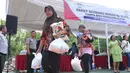Warga membawa sembako usai mendapatkan paket sembako murah yang diadakan Indosiar di Joglo, Jakarta, Senin (13/6). Paket berisikan 5 kg beras, 2 liter minyak goreng, 1 kg gula pasir dan 1 kg tepung terigu dijual Rp 30 ribu‎. (Liputan6.com/Angga Yuniar)