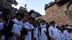 Sejumlah wanita Yazidi Irak mengenakan pakaian tradisional berkumpul di luar kuil Lalish untuk merayakan Tahun Baru Yazidi di lembah dekat Dohuk, Irak (17/4). (AFP/Safin Hamed)