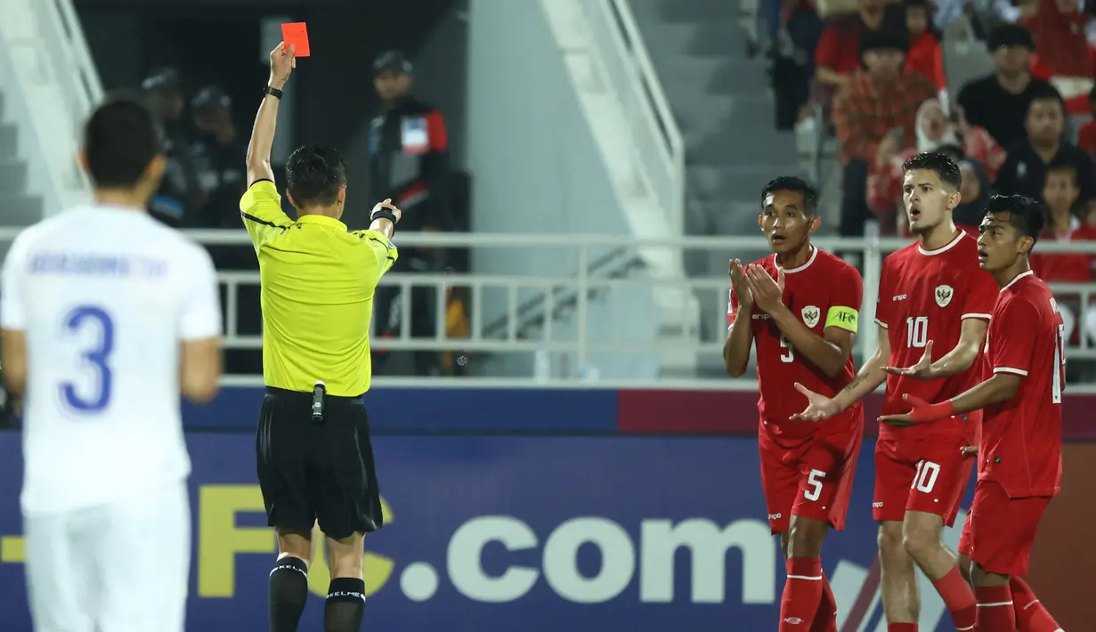 <p>Wasit Shen Yinhao memberi kartu merah kepada kapten Timnas Indonesia U-23, Rizky Ridho (ketiga kanan) saat menghadapi Uzbekistan U-23 pada laga semifinal Piala Asia U-23 2024 di Abdullah bin Khalifa Stadium, Doha, Qatar, Senin (29/4/2024). (AFP/Karim Jaafar)</p>
