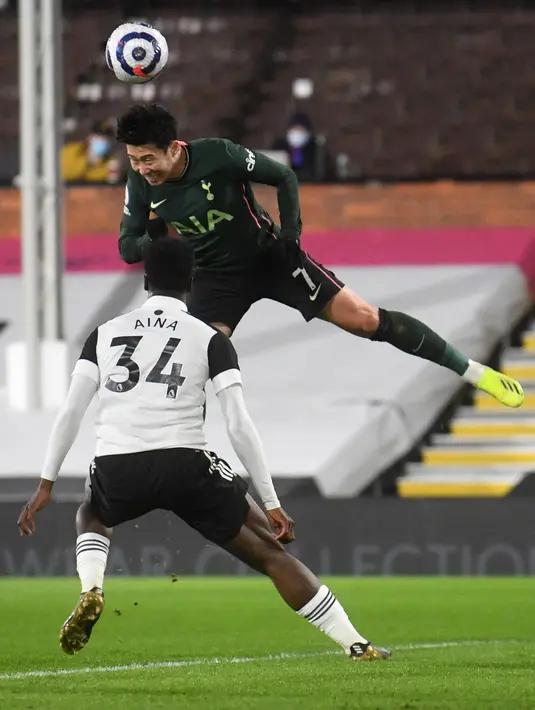 Striker Tottenham Hotspur, Son Heung-Min (atas) bersaing dengan bek Fulham, Ola Aina pada pekan ke-27 Liga Inggris di Craven Cottage, Jumat (5/3/2021) dini hari WIB. Tottenham Hotspur unggul 1-0 atas Fullham lewat gol bunuh diri Tosin Adarabioyo. (NEIL HALL / POOL / AFP)