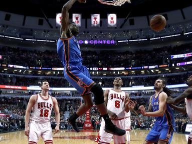 Aksi pemain Oklahoma City Thunder, Jerami Grant melakukan dunks saat melawan Chicago Bulls pada laga NBA basketball game di United Center, (9/1/2017). Thunder menang 109-94. (AP/Charles Rex Arbogast)