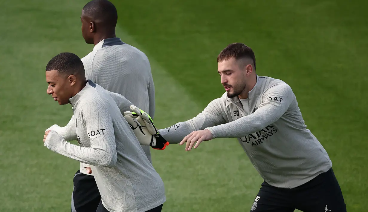 Penyerang Paris Saint-Germain Kylian Mbappe dan kiper Arnau Tenas (kanan) menghadiri sesi Latihan menjelang leg kedua semifinal Liga Champions 2023/2024 di Campus PSG di Poissy, Senin (6/5/2024). (FRANCK FIFE / AFP)