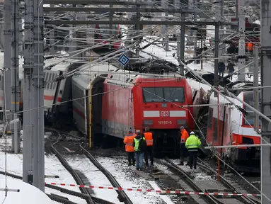 Regu penyelamat berdiri dekat dua rangkaian kereta penumpang yang terlibat tabrakan dekat stasiun di Niklasdorf, Austria, Senin (12/2). Tabrakan kereta itu menyebabkan satu orang tewas dan 22 lainnya terluka, tiga di antaranya anak-anak. (AP/Ronald Zak)