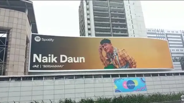Wajah Jaz terpampang di layar digital raksasa di pusat perbelanjaan Ratu Plaza.