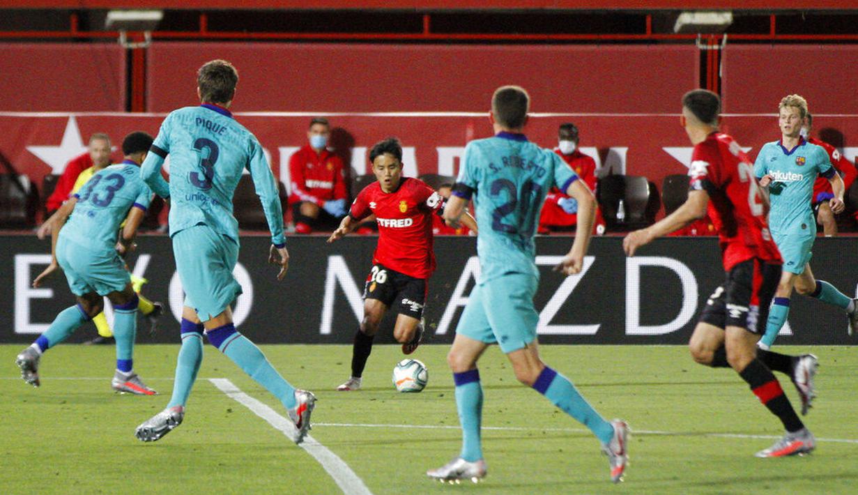 Pemain Mallorca, Takefusa Kubo, menggiring bola saat melawan Barcelona pada laga La Liga di Estadio de Son Moix, Minggu (14/6/2020). Barcelona menang dengan skor 4-0. (AP/Francisco Ubilla)