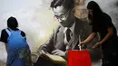 Dua mahasiswa seni di Thailand melukis gambar mendiang raja Raja Bhumibol Adulyadej di Universitas Silpakorn di Bangkok, Senin (17/10). Sejak wafatnya Raja Bhumibol, banyak warga memberikan macam-macam bentuk penghormatannya. (Reuters/Athit Perawongmetha)