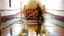 Pekerja mengeringkan air hujan yang membanjiri jalur pejalan kaki Union Station ke arah ke peron kereta api di Los Angeles, California, Amerika Serikat, 10 Januari 2023. Serangkaian badai yang menghantam California telah menyebabkan jalanan terendam banjir, gelombang tinggi air laut, sungai meluap, dan memaksa ribuan orang untuk mengungsi. (AP Photo/Damian Dovarganes)
