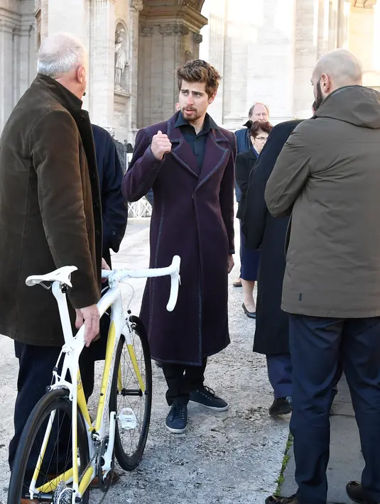 Juara sepeda dunia asal Slovakia, Peter Sagan (tengah) membawa sepedanya yang akan di berikan kepada kepada Paus Fransiskus pada akhir audiensi mingguan di Vatikan (24/1). (AFP/HO)