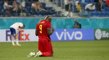 Penyerang timnas Belgia, Romelu Lukaku berlutut di lapangan pada akhir Matchday 1 Grup B Euro 2020 kontra Rusia di Stadion Saint-Petersburg, Minggu (13/6/2021) dini hari WIB. Rusia berhasil mengandaskan Rusia dengan skor 3-0 dengan dua gol dari Romelu Lukaku. (Anatoly Maltsev/Pool via AP)