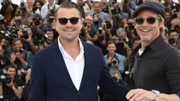 Aktor Brad Pitt dan Leonardo DiCaprio tersenyum saat berpose menghadiri pemutaran film 'Once Upon a Time in Hollywood' selama Festival Film Cannes Internasional ke-72 di Prancis (22/5/2019). (AP Photo/Vianney Le Caer)