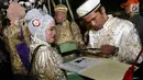 Sejumlah pasangan mengikuti nikah massal di malam pergantian tahun di Jalan MH Thamrin, Jakarta, Minggu (31/12). Sebanyak 430 pasangan melakukan nikah massal yang diselenggarakan oleh pemprov DKI Jakarta. (Liputan6.com/Angga Yuniar)