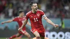 Berstatus tim debutan di Piala Dunia 2022, Wales sukses meraup satu poin dan terhindar dari kekalahan dalam laga menghadapi Amerika Serikat pada matchday pertama Grup B, Selasa (22/11/2022) dini hari WIB. Bertanding di Ahmad Bin Ali Stadium, Doha, Qatar, Gareth Bale dkk berbagi skor 1-1 dengan Tim Paman Sam. Tertinggal lebih dahulu lewat gol Timothy Weah pada babak pertama, Wales baru berhasil menyamakan skor pada menit ke-82 via eksekusi penalti Gareth Bale. (AP/Ashley Landis)