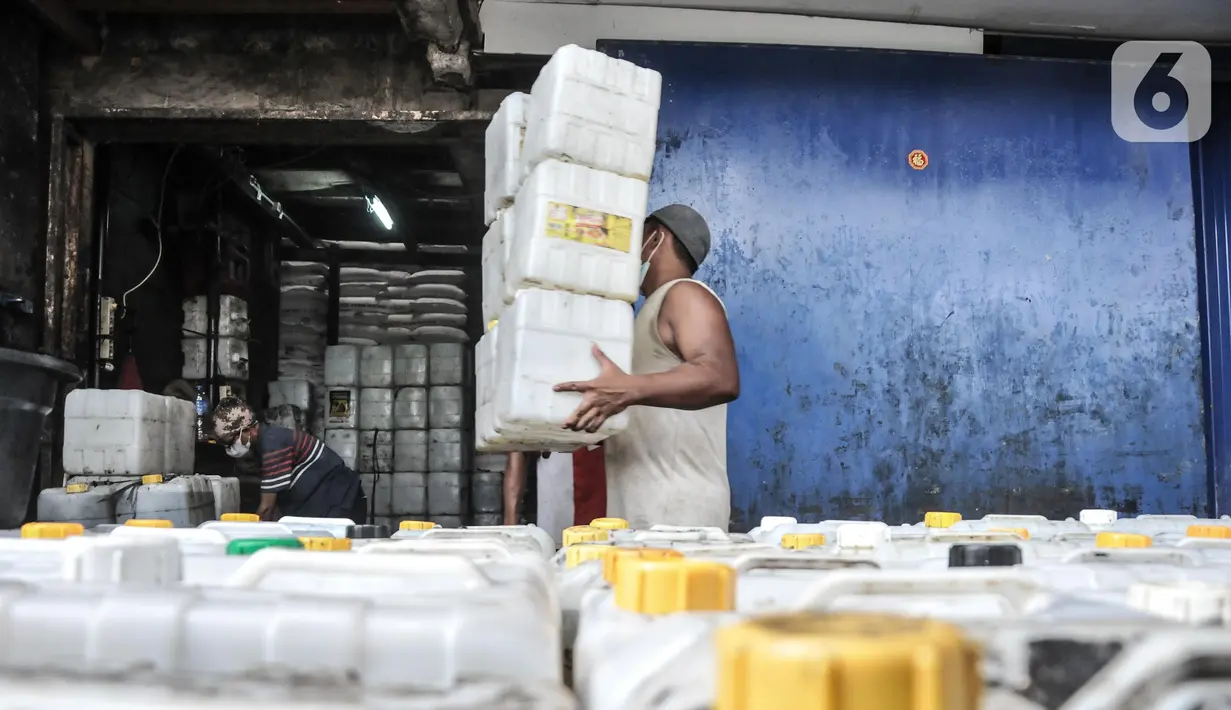 Pekerja membawa jeriken berisi minyak goreng di kawasan Pasar Kebayoran Lama, Jakarta, Rabu (25/5/2022). Nantinya program minyak goreng curah akan diganti dengan kebijakan domestic market obligation (DMO) dan domestic price obligation (DPO). Saat ini harga minyak curah dibanderol Rp16.000 per kilogram. (merdeka.com/Iqbal S Nugroho)