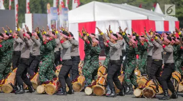 Prajurit TNI dan Polri berkolaborasi memainkan rampak gendang dalam HUT ke-73 Bhayangkara di Monas, Jakarta, Rabu (10/7/2019). HUT Bhayangkara ke-73 ini bertemakan ‘Dengan semangat Promoter, pengabdian Polri, untuk masyarakat, bangsa, dan negara. (Liputan6.com/Faizal Fanani)