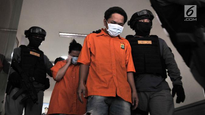 Polisi menggiring dua tersangka kasus prostitusi online di Apartemen Kalibata City, Jakarta, Minggu (6/5). Polisi mengamankan dua tersangka berinisial H alias A (31) dan M alias R (35) selaku muncikari. (Merdeka.com/Iqbal Nugroho)
