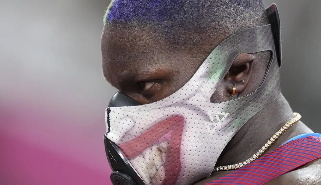 Atlet tolak peluru Amerika Serikat, Raven Saunders menunggu untuk berlaga di babak kualifikasi pukulan putri di Olimpiade Musim Panas 2020 di Tokyo, Jumat (30/7/2021). Saunders  tampil dengan menggunakan masker musuh Batman, Joker dengan rambut berwarna ungu dan hijau. (AP Photo/Matthias Schrader)