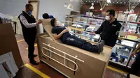 Rodolfo Gomez dan karyawannya mendemonstrasikan desain kardus mereka dapat berfungsi sebagai tempat tidur rumah sakit dan peti mati untuk pasien COVID-19 di Bogota, Kolombia, Jumat (8/5/2020). Perusahaan ini menanggapi kekurangan tempat tidur dan peti mati selama pandemi.  (AP/Fernando Vergara)