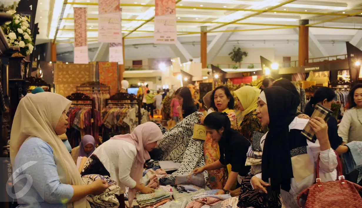 Beberapa pengunjung memilih kain batik pada pameran WARISAN 2016 di Jakarta, Kamis (25/8). Pameran wastra batik ini menampilkan karya pebatik terbaik Indonesia baik tulis maupun cap dengan nuansa yang berbeda. (Liputan6.com/Helmi Fithriansyah)