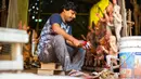 Seorang perajin menyiapkan cat warna saat membuat patung dewi Durga menjelang festival 'Durga Puja' di sebuah workshop di New Delhi, India, Rabu (14/10/2020). Durga Puja merupakan festival tahunan di Asia Selatan untuk memuja dewi Durga dari agama Hindu. (Photo by Jewel SAMAD / AFP)