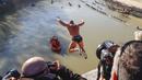 Simone Carabella dari Italia melompat ke Sungai Tiber dari Jembatan Cavour setinggi 18 meter (59 kaki) untuk merayakan Tahun Baru di Roma, 1 Januari 2022. (AP Photo/Riccardo De Luca)
