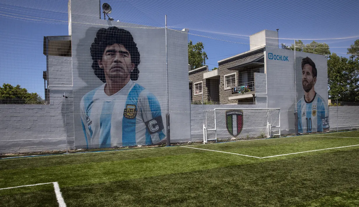 Mural bintang sepak bola Diego Maradona (kiri) dan Lionel Messi (kanan) menghiasi lapangan sepak bola pribadi "Giuseppe Meazza" di Buenos Aires, Argentina, Rabu (24/11/2021). Peringatan pertama kematian Maradona digelar pada 25 November 2021. (AP Photo/Rodrigo Abd)