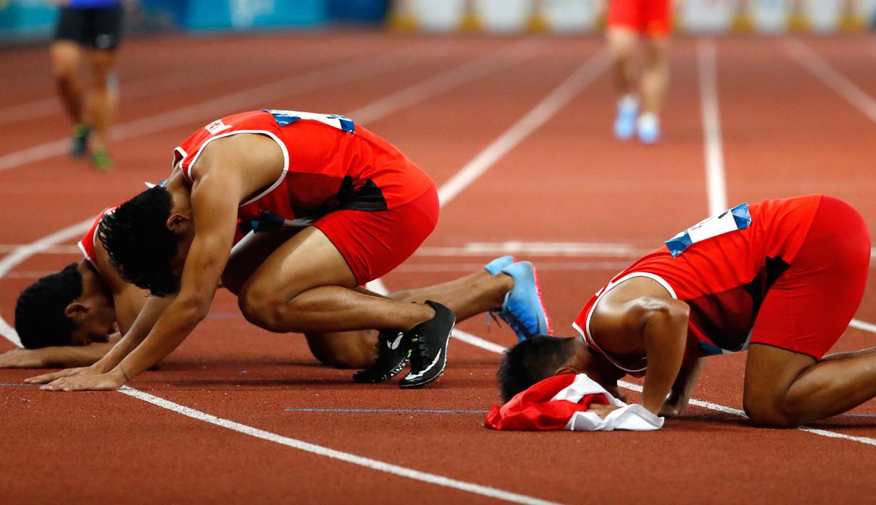 Lalu Muhammad Zohri (tengah) bersama Fadlin, Eko Rimbawan, dan Bayu Kertanegara sujud syukur usai meraih perak dalam final lari 4x100 meter cabang olahraga atletik Asian Games 2018 di Jakarta, Kamis (30/8). (AP Photo/Bernat Armangue)