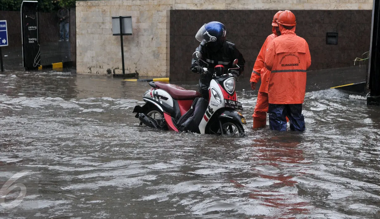 Seorang pengendara motor mendorong kendaraanya yang mogok akibat menerobos banjir di kawasan Kemang, Jakarta Selatan, Rabu (26/4). Hujan deras yang mengguyur wilayah Jakarta menyebabkan banjir di kawasan Jalan Kemang Raya. (Liputan6.com/Yoppy Renato)