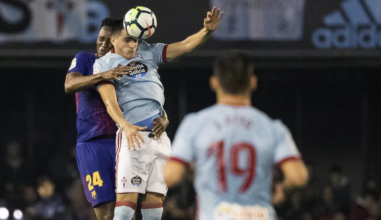 Bek Barcelona, Yerry Mina, duel udara dengan pemain Celta Vigo, Maxi Gomez, pada laga La Liga di Stadion Balaidos, Rabu (18/4/2018). Celta Vigo bermain imbang 2-2 dengan Barcelona. (AP/Lalo R. Villar)