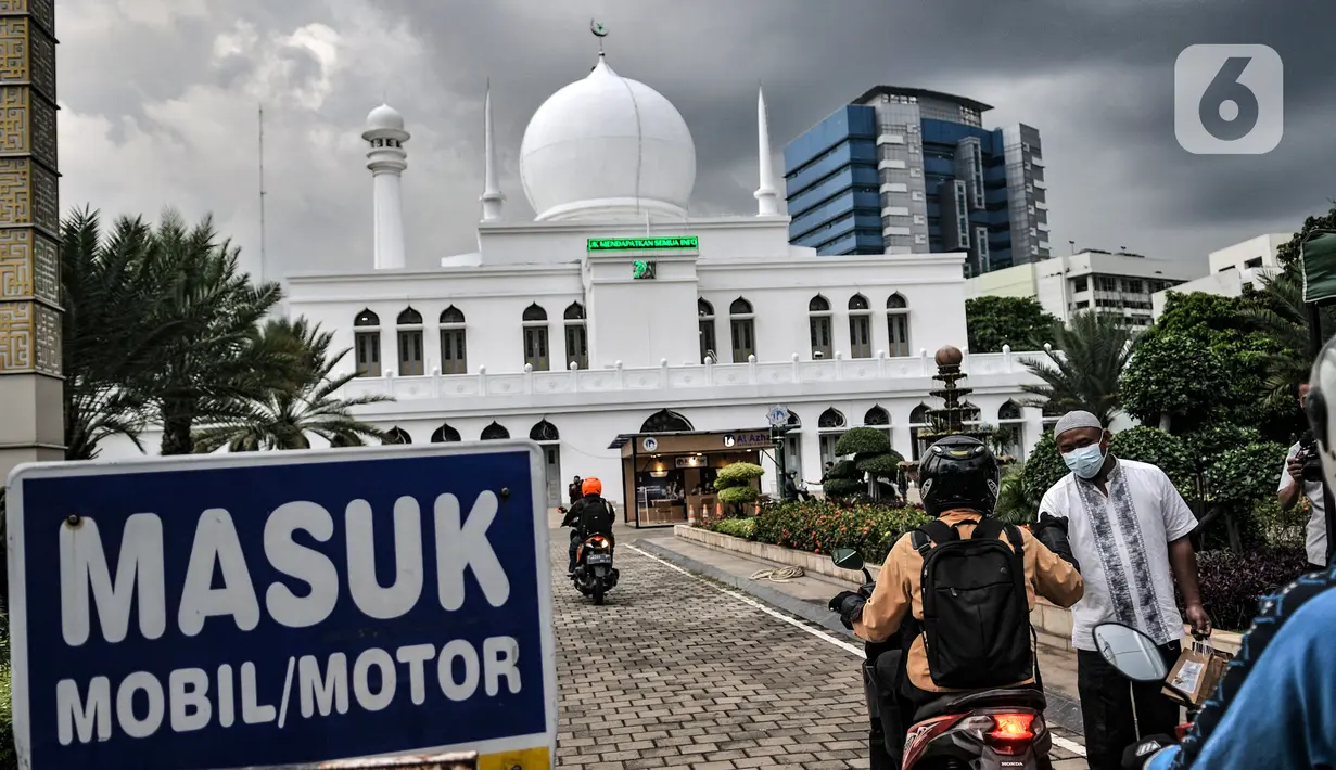 Petugas membagikan takjil kepada pengendara secara drive thru di Kompleks Masjid Al-Azhar, Jakarta, Selasa (13/4/2021). Pengelola Masjid Al-Azhar menyiapkan 500 bungkus takjil per hari yang dibagikan secara drive thru guna mencegah penyebaran COVID-19. (merdeka.com/Iqbal S. Nugroho)