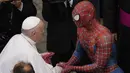 Paus Fransiskus bertemu Spider-Man, yang memberinya masker, pada akhir audiensi umum mingguan dengan jumlah umat terbatas di San Damaso Courtyard, Vatikan, Rabu (23/6/2021). Pria itu adalah Mattia Villardita (27) dari Italia utara yang menghibur anak-anak di rumah sakit. (AP Photo/Andrew Medichini)