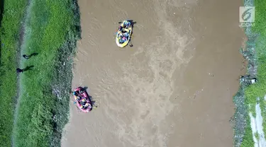 Peserta dengan perahu karet  menyusuri Sungai Ciliwung sambil membersihkan sampah pada acara Bersih-Bersih Sungai Ciliwung, Jakarta, Minggu (08/4). Kegiatan tersebut merupakan rangkaian HUT Kementerian BUMN. (Liputan6.com/Fery Pradolo)