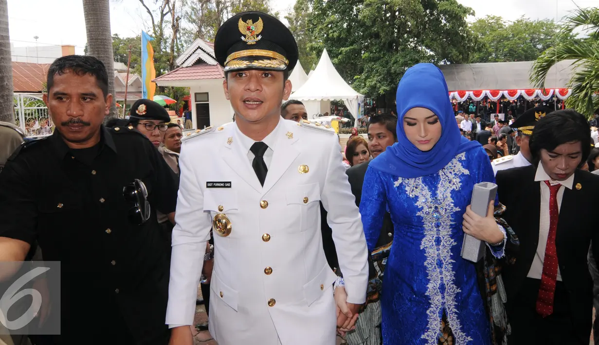 Sigit Purnomo Said atau akrab disapa Pasha Ungu mengggandeng erat tangan istrinya Adelia Pasha usai dilantik di halaman kantor itu, Rabu (17/2). Pasha berhasil mengalahkan tiga pasagan lainnya dalam Pilkada di Palu. (Liputan6.com/Dio Pratama)