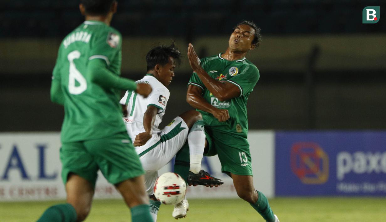 Bek PS Sleman, Samsul Arifin (kanan) berebut bola dengan striker Persebaya Surabaya, Moch Supriadi dalam laga Grup C Piala Menpora 2021 di Stadion Si Jalak Harupat, Bandung, Rabu (7/4/2021). (Bola.com/Ikhwan Yanuar)