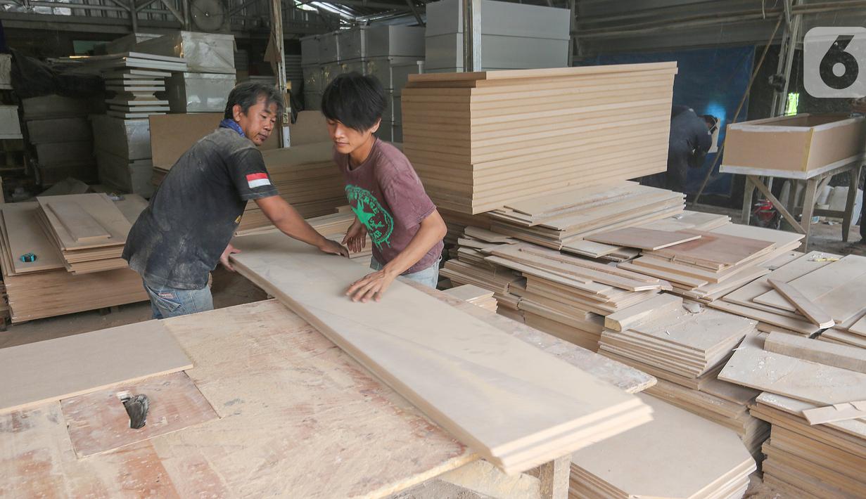Pekerja memotong papan MDF untuk bahan membuat peti mati Covid-19 di Rawa Mekar Jaya, Serpong, Tangerang Selatan, Kamis (21/01/2021). Peti mati yang dijual dengan harga Rp 1 juta mampu memproduksi 3 peti per hari yang didistribusi di wilayah Jabodetabek. (Liputan6.com/Fery Pradolo)