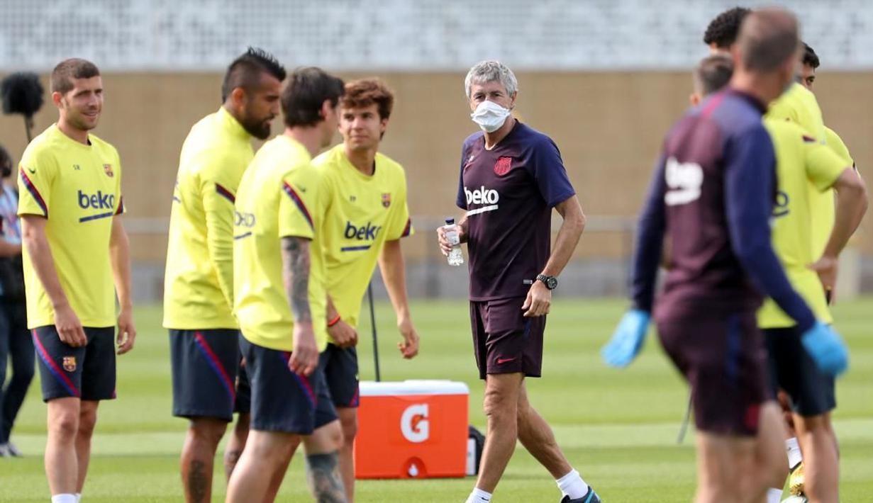 Pelatih Barcelona, Quique Setien, mengamati anak asuhnya saat menggelar latihan di Joan Gamper, Barcelona, Senin (25/5/2020). Latihan tersebut untuk persiapan jelang kembali bergulirnya La Liga Spanyol. (AFP/Miguel Rui)