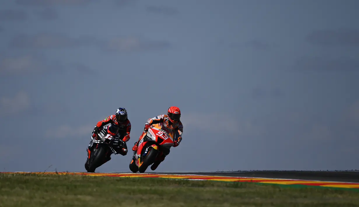 Pembalap Aprilia Racing, Maverick Vinales (kiri) dan pebalap Repsol Honda Marc Marquez memacu kecepatan sepeda motornya pada sesi latihan bebas kedua balapan MotoGP Aragon 2022 di sirkuit Motorland di Alcaniz, Spanyol, Jumat (16/9/2022). (PIERRE-PHILIPPE MARCOU / AFP)