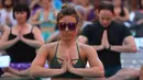 Seorang wanita melakukan gerakan yoga di tengah jalan Times Square, New York pada 'Summer Solstice' atau hari dengan siang terpanjang di musim panas, Rabu (21/6). Acara itu menandai Hari Yoga Internasional yang jatuh pada 21 Juni. (TIMOTHY A. CLARY/AFP)