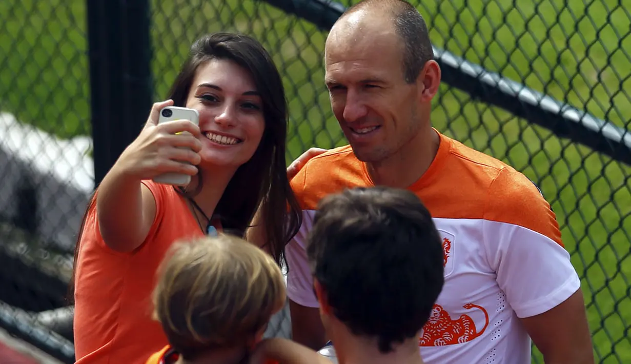 Usai berlatih di Rio de Janeiro, gelandang serang Timnas Belanda, Arjen Robben, memenuhi permintaan suporternya untuk berfoto bersama, (2/7/2014). (REUTERS/Pilar Olivares)