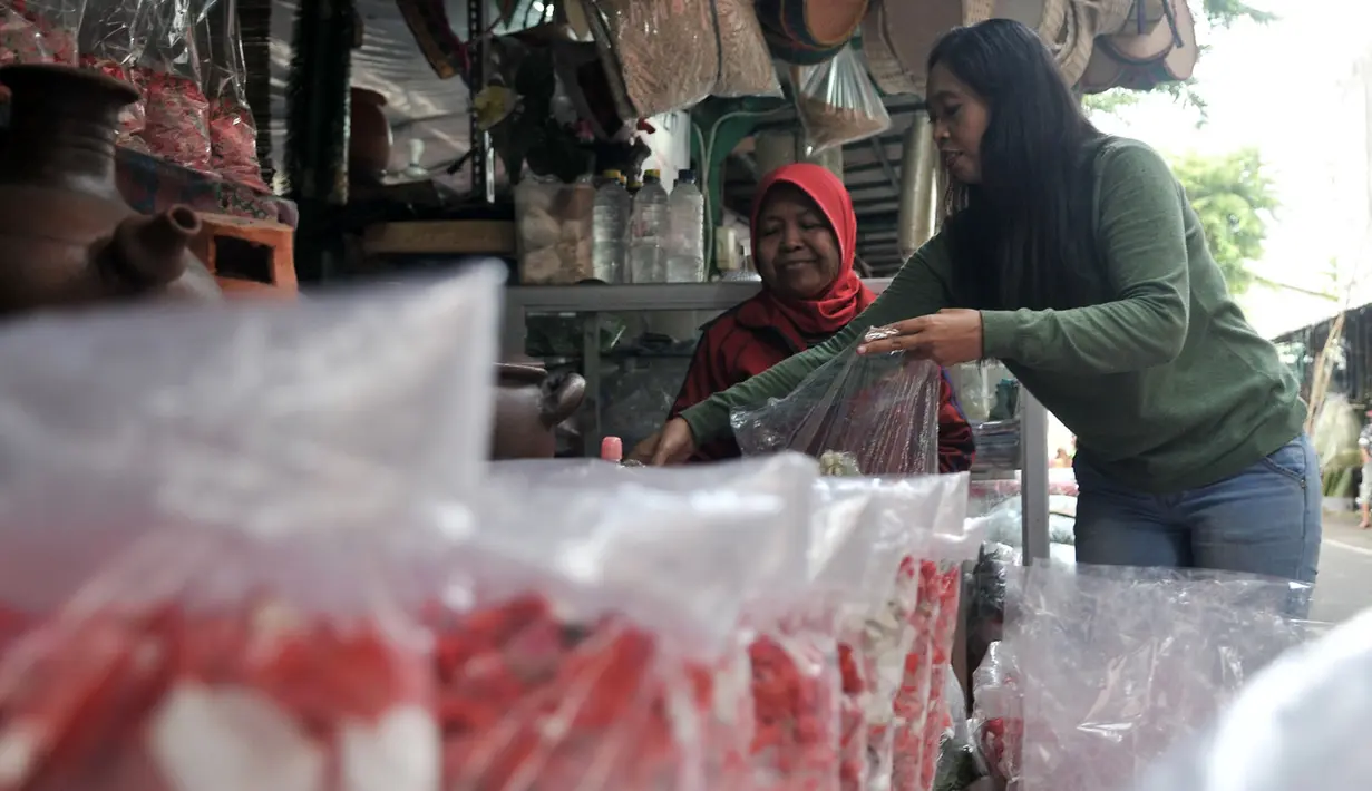 Pedagang melayani pembeli di salah satu kios kembang makam di Pasar Rawa Belong, Jakarta, Senin (29/4). Pasar Rawa Belong merupakan pusat grosir aneka kembang makam yang diburu oleh para pedagang kembang makam di Ibu Kota. (merdeka.com/Iqbal Nugroho)