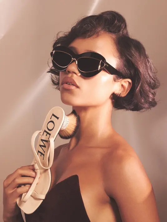 Sedangkan teksturnya yang menonjol, bulu berlian imitasi, suede, bulu domba, mengacu pada komposisi yang sureal. Simbol alegoris ini terbawa dari kampanye FW23 untuk koleksi pria, dalam gambar trio model yang berbaring di atas meja dengan gaun bulu dan Squeeze Bag di tangan mereka. [Foto: Document/LOEWE]