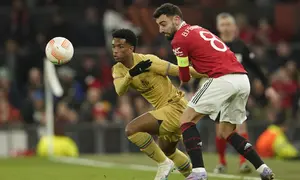 Gelandang Manchester United, Bruno Fernandes berebut bola dengan pemain Barcelona, Alejandro Balde selama pertandingan leg kedua playoff Liga Europa stadion Old Trafford di Manchester, Inggris, Jumat (24/2/2023). Hasil ini membuat MU lolos dengan agregat kemenangan 4-3 atas Barcelona. (AP Photo/Dave Thompson)