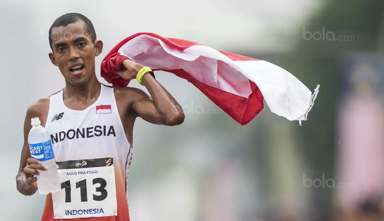 Pelari Indonesia, Agus Prayogo, melakukan selebrasi usai tampil pada nomor marathon SEA Games di Putrajaya, Kuala Lumpur, Sabtu (19/8/2017). Agus meraih medali perak dengan waktu dua jam 27 menit 16 detik. (Bola.com/Vitalis Yogi Trisna)